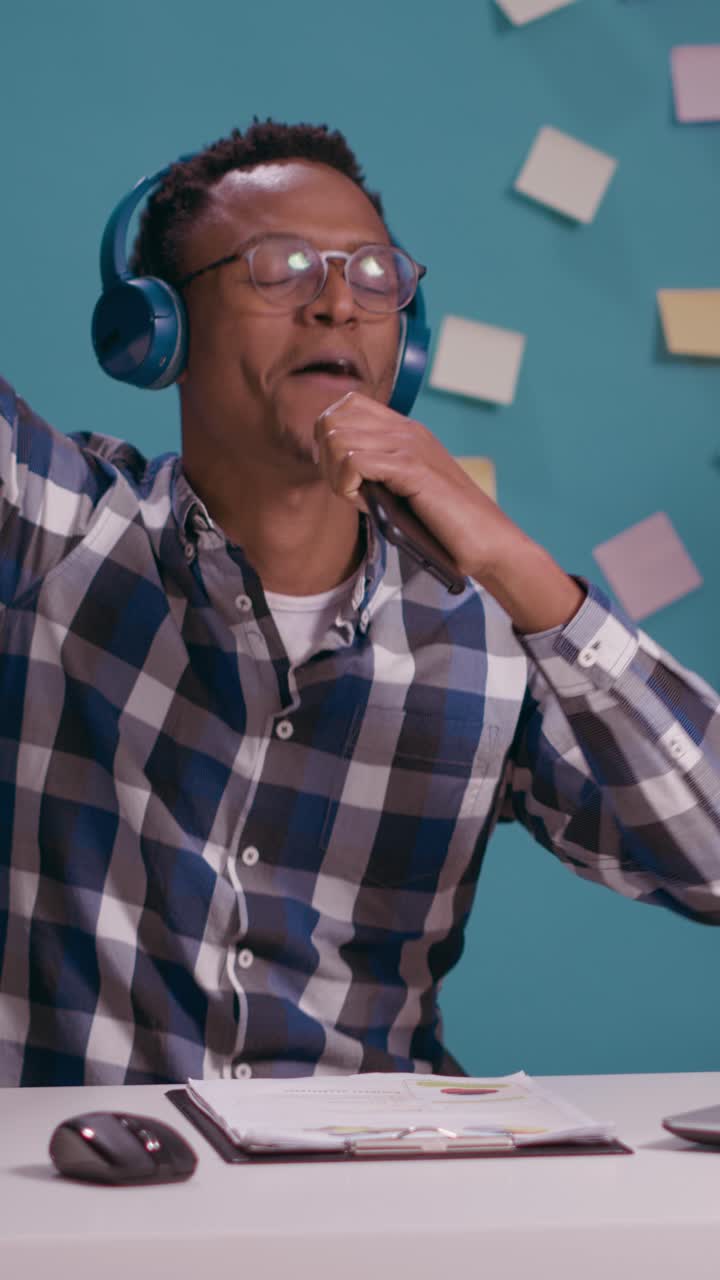 Man wearing headphones at desk with charts