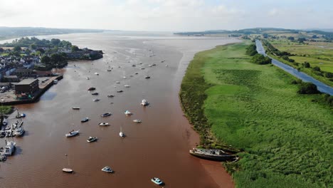 scenic aerial view of sailboats anchored in river exe beside green fields and exeter canal