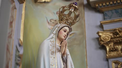 estatua de la virgen maría con corona ornamentada en el entorno de la iglesia