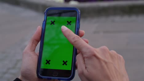 pantalla verde de la llave de croma del teléfono celular con la mano