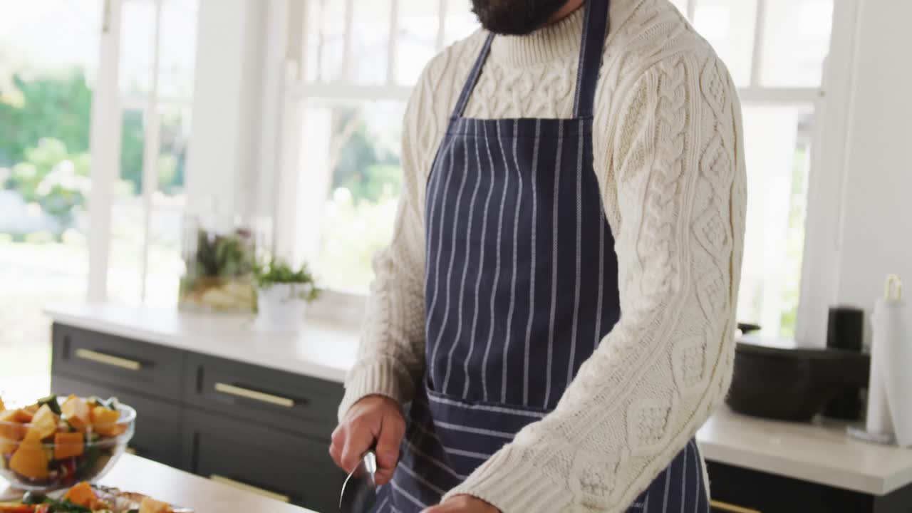 Video von kaukasischen Männern, die in der Küche eine Mahlzeit zubereiten.