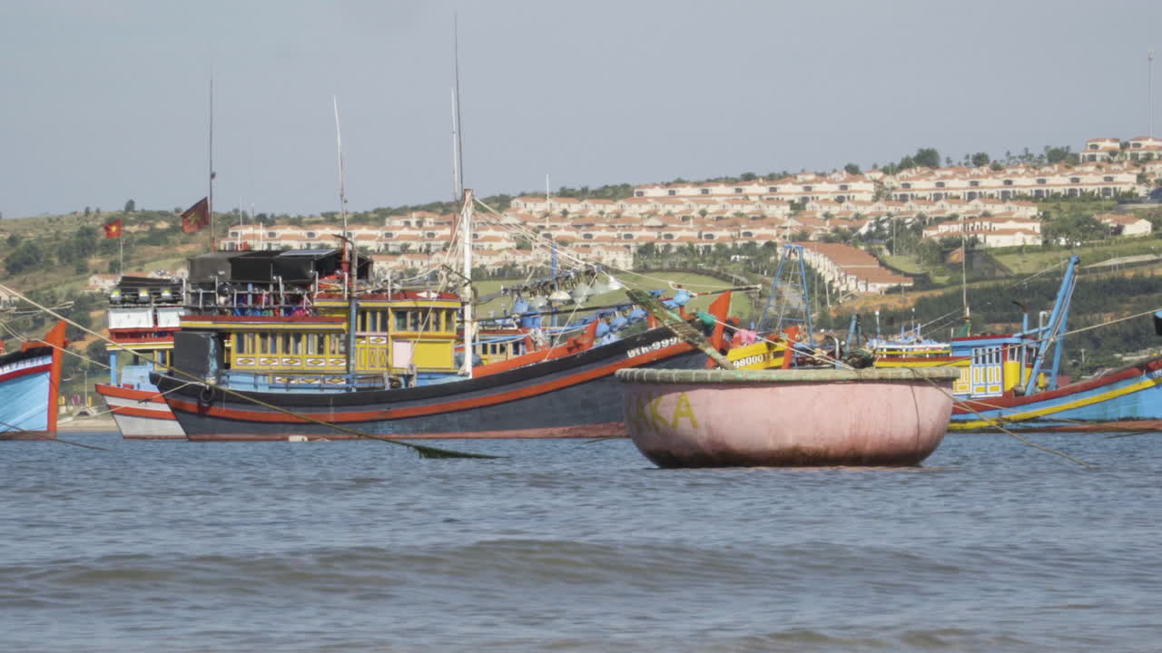 contraste entre los barcos de pescadores vietnamitas pobres y las villas de lujo en el fondo