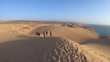 hikers walking in the dunes of the moroccan desert