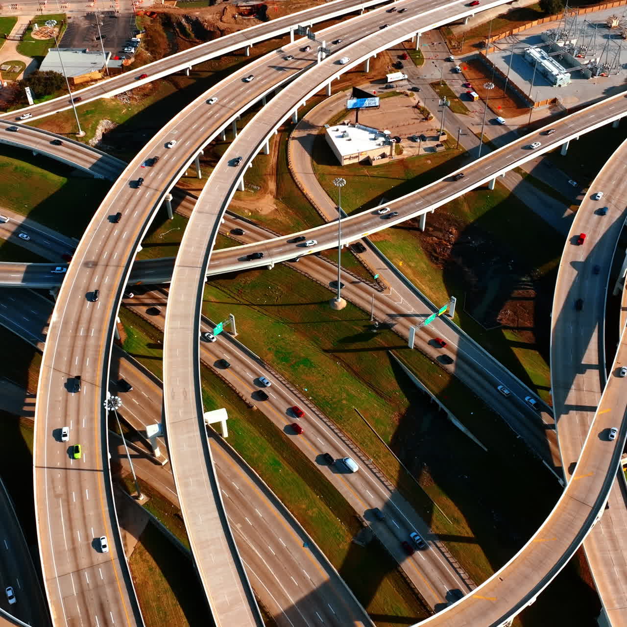 Footage above the web of roads in the downtown of Dallas, Texas, USA. Multiple cars run by the highways and freeways