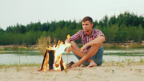 Lone-Serious-Man-Sitting-By-The-Campfire-Roast-Marshmallows-On-A-Stick-Prors-Hq-422-10-Bit-Slow-Moti
