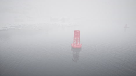 red metal buoy floating in cold norwegian sea