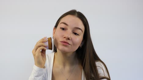 impresionante joven caucásica mujer morena aplicando maquillaje en la preparación de la mañana