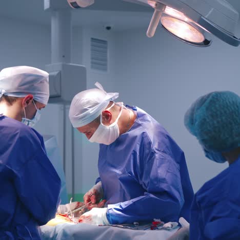 team of surgeons perform an operation. professional doctor with assistants doing a surgery with medical instruments in the surgery room.