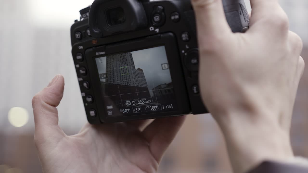 Hands holding a Nikon camera