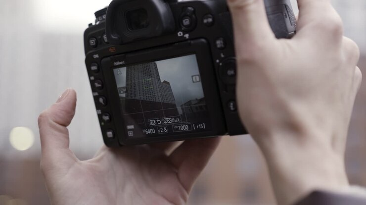 Hænder der holder et Nikon kamera