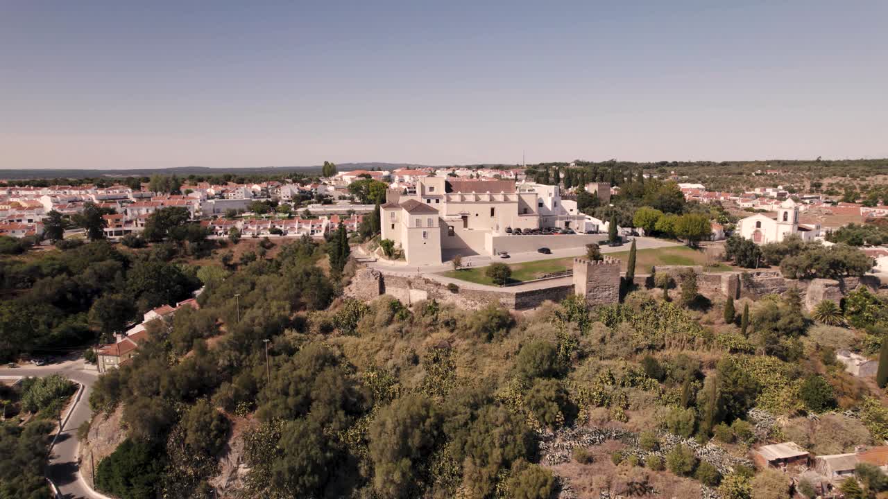toma panorámica del histórico castillo de alcacer do sal en la cima de la colina contra el cielo azul claro