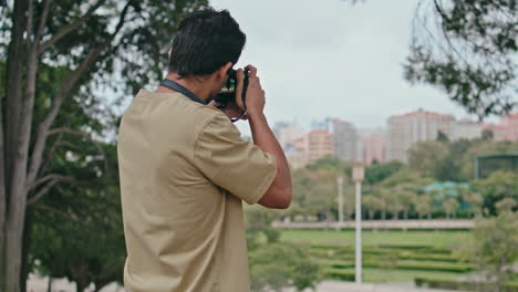 urban photographer making photo cityscape in park closeup. tourist photographing