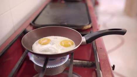 person frying eggs on pan