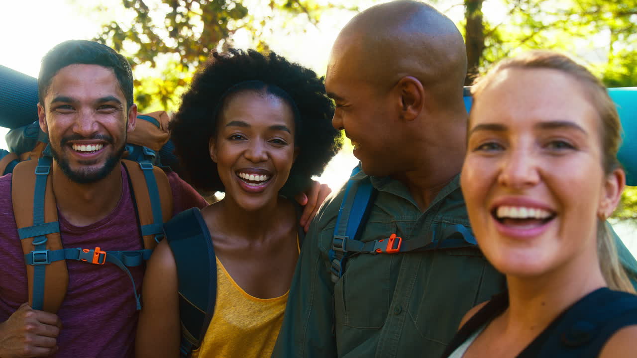 grupo de amigos con mochilas posando para una selfie en el teléfono móvil en vacaciones de senderismo en el campo