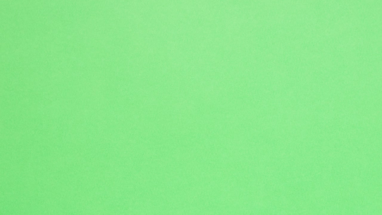 Blue crumpled paper unfolds on green in a stop motion transition
