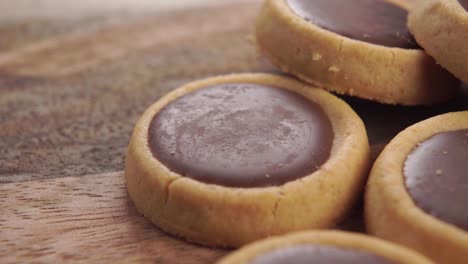 round small shortbread cookies with chocolate filling on a wooden rustic table. macro