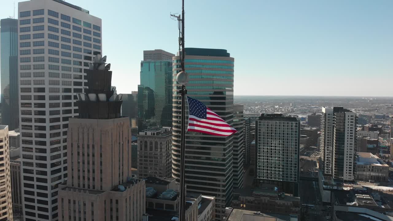 Riprese aeree della bandiera americana, che sventola al contrario, con il centro di Minneapolis sullo sfondo