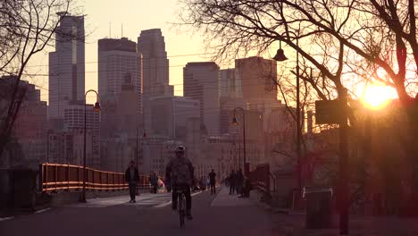 Hermosa-Foto-De-Peatones-Caminando-Al-Atardecer-Con-El-Fondo-Del-Horizonte-De-Minneapolis-Minnesota