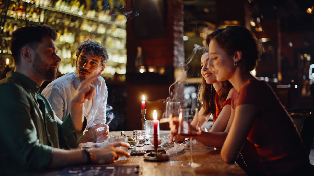 Relaxed people smoking bar enjoying night gathering closeup. Happy friends bar