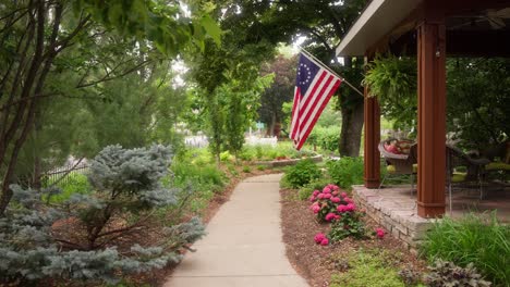 Toma-Estática-De-Un-Sendero-Para-Caminar-En-El-Patio-Delantero-De-Una-Casa-Con-Una-Bandera-Estadounidense-De-Betsy-Ross.