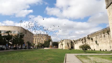 Tauben-Fliegen-In-Zeitlupe-Um-Die-Mauern-Der-Burg-Karls-V.-In-Lecce,-Italien