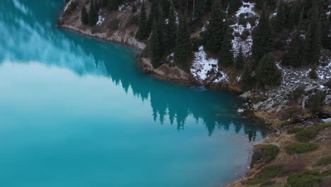 toma cinematográfica de drones del agua del lago de color turquesa en el gran lago almaty en las montañas trans-ili alatau en kazajstán