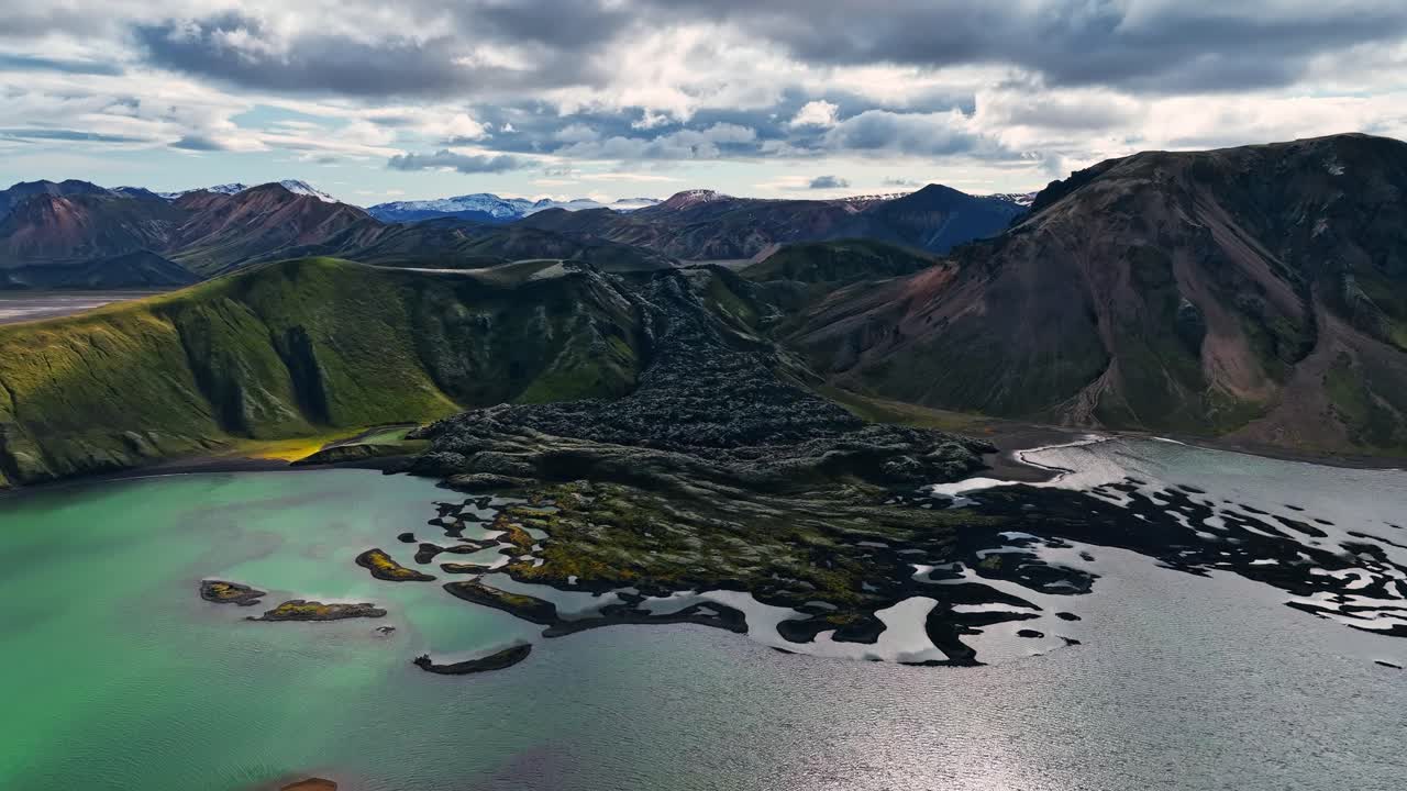 Aerial view of a volcanic landscape with mountains and a lake in Iceland