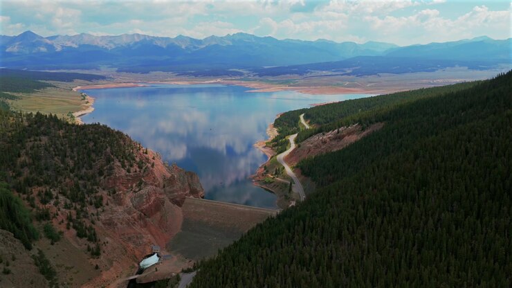 Diga del bacino idrico di Taylor Park, barche estive che pescano nel fiume Taylor, Cime Collegiate, drone aereo, Almont, Colorado centrale, Catena montuosa Sawatch, Montagne Rocciose, Contea di Gunnison, strada ventosa, mattina soleggiata, panoramica in avanti verso l'alto