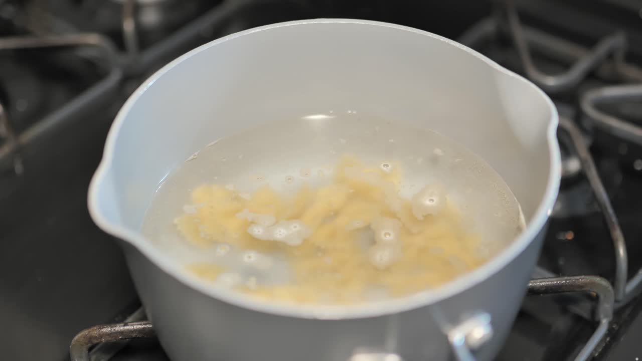 Pentola su un fornello che cuoce la pasta in acqua bollente