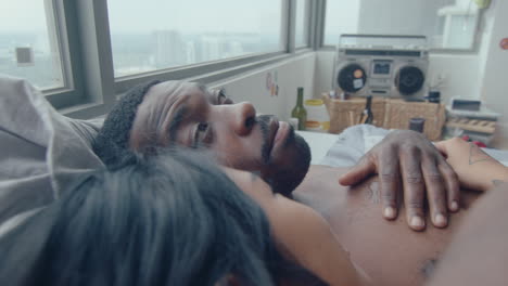 black man embracing girlfriend and telling the story in bed