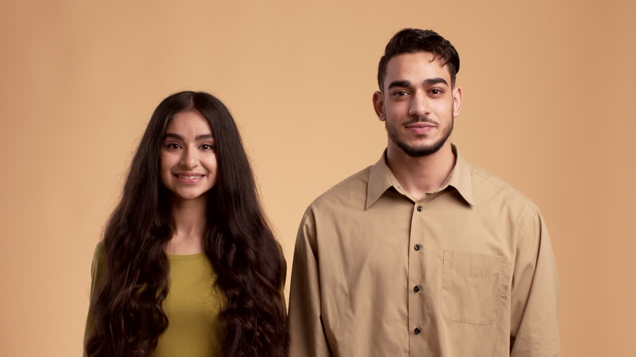 una pareja feliz dando los pulgares hacia arriba.