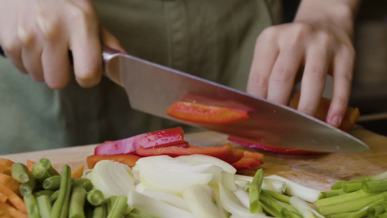 Hands chopping fresh vegetables on a cutting board