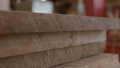 lumber boards in a stack in a workshop, close up with slow track left