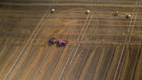 Antena-De-Arriba-Hacia-Abajo---Un-Tractor-Con-Una-Máquina-Especializada-Crea-Fardos-De-Paja---Tecnología-En-Agricultura---Mejora-De-La-Eficiencia-Del-Trabajo-De-Campo