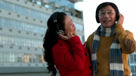 Couple-in-warm-clothes-enjoying-music-together