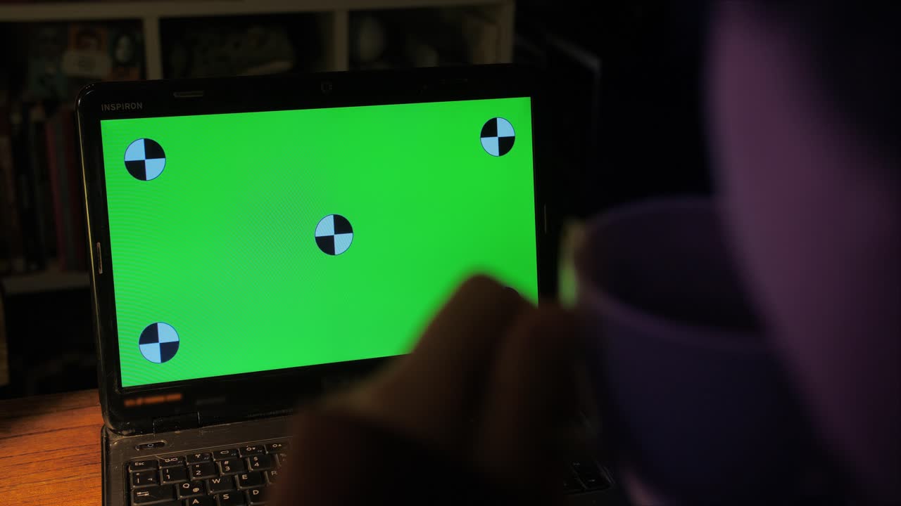 Persona tecleando en un portátil con pantalla verde de noche