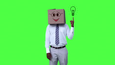 Happy-anonymous-businessman-with-box-on-head-and-pointing-cartoon-light-bulb