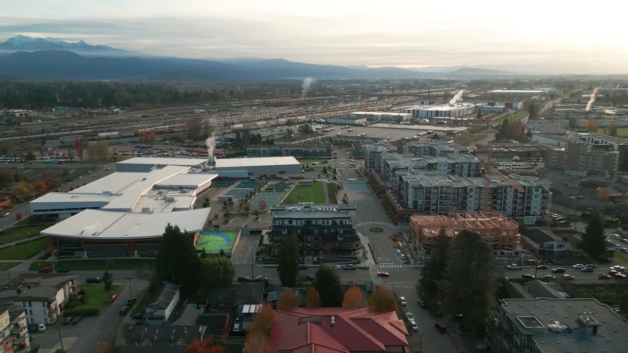 an arial shot of a residential district of port coquitlam, with the community central on the left and a train station in the background.