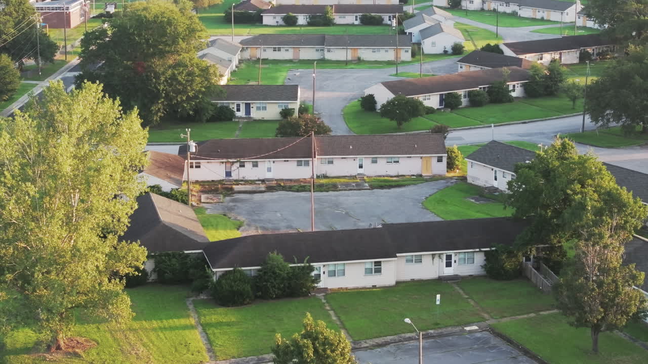 Cinematic drone shot of abandoned apartments with vegetation growing on the buildings, revealing aerial footage
