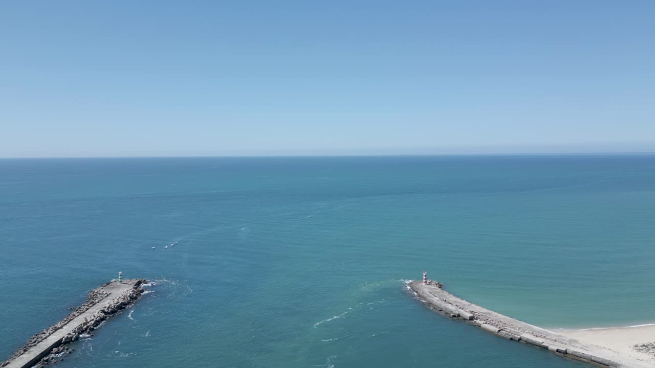 воздушный вид двух волноразрушителей в бетонном пирсе в алгарве, окруженный потрясающими водами атлантического океана