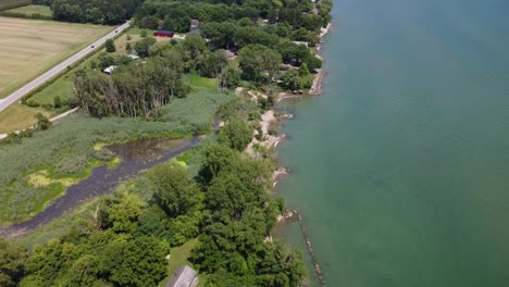 aerial 4k drone footage of small homestead cottages along lake erie shoreline