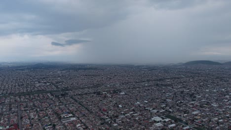 Drone footage observing a storm falling over Mexico City during rainy season