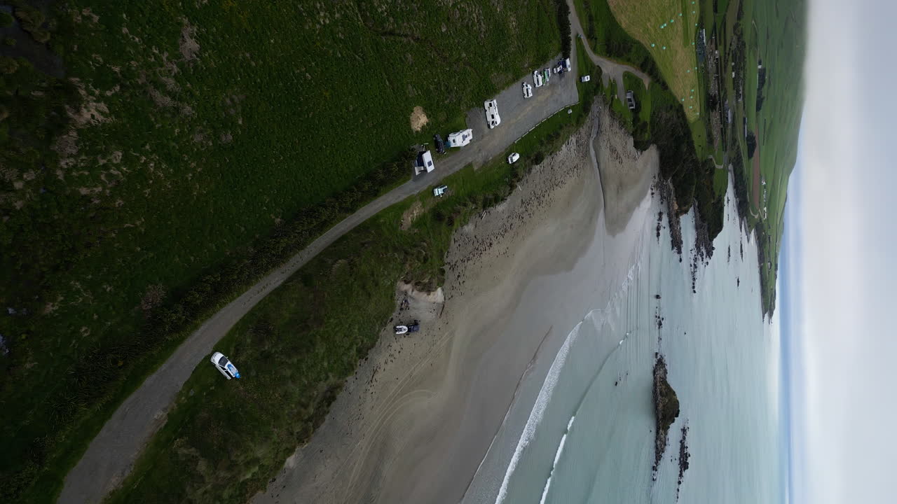 뉴질랜드의 모래 해변과 해안 주차장, 공중 드론 세로 보기