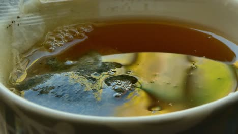 close up of water falling in a cup of tea