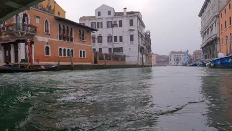 low angle pov of boat passing under ponte delle guglie bridge in venice, italy