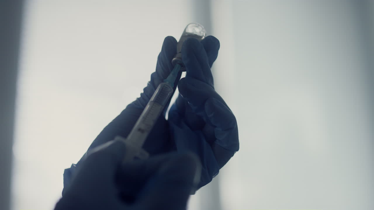 las manos del médico llenando la jeringa con medicamentos de cerca. vacuna en la clínica de salud.