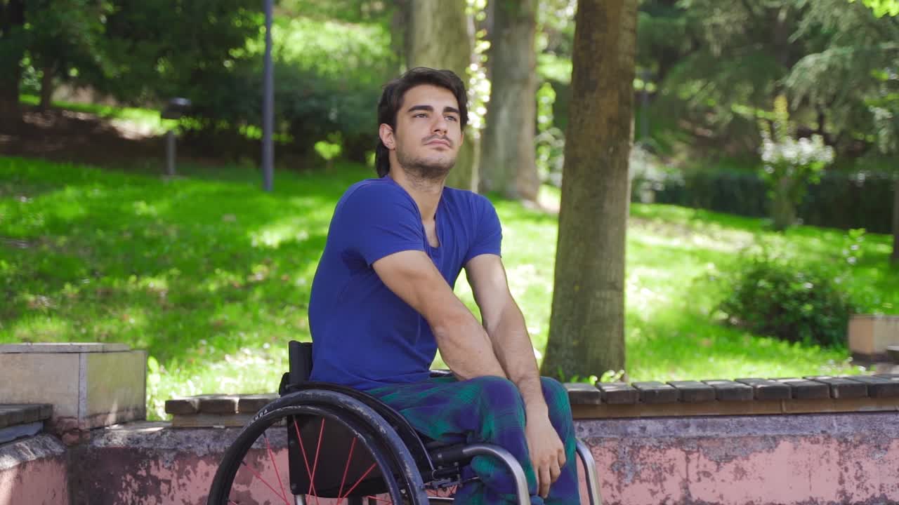 Disabled teenager thinking and dreaming in a wheelchair. Slow Motion.