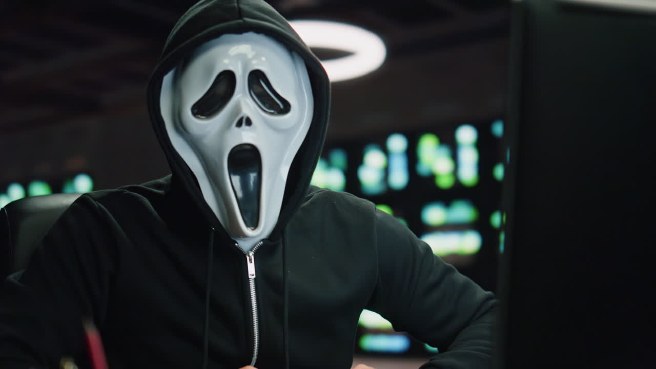 hacker anónimo rompiendo servidores de datos en el cuarto nocturno de primer plano. hombre mirando cámara