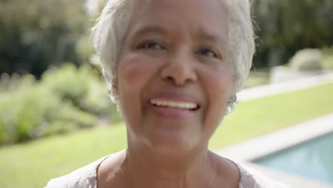 Retrato-De-Una-Feliz-Mujer-Birracial-Mayor-Mirando-La-Cámara-Y-Sonriendo-En-El-Jardín,-Cámara-Lenta