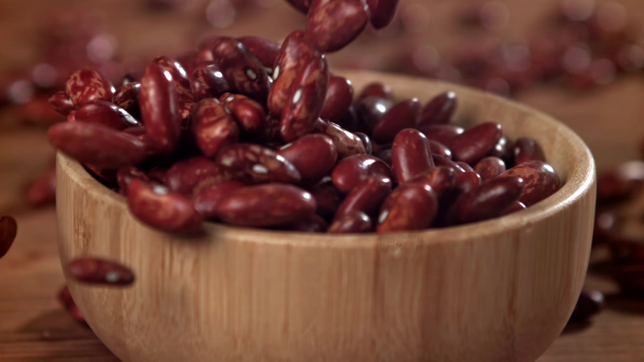 Red Kidney Beans Falling into a Wooden Bowl in Slow Motion